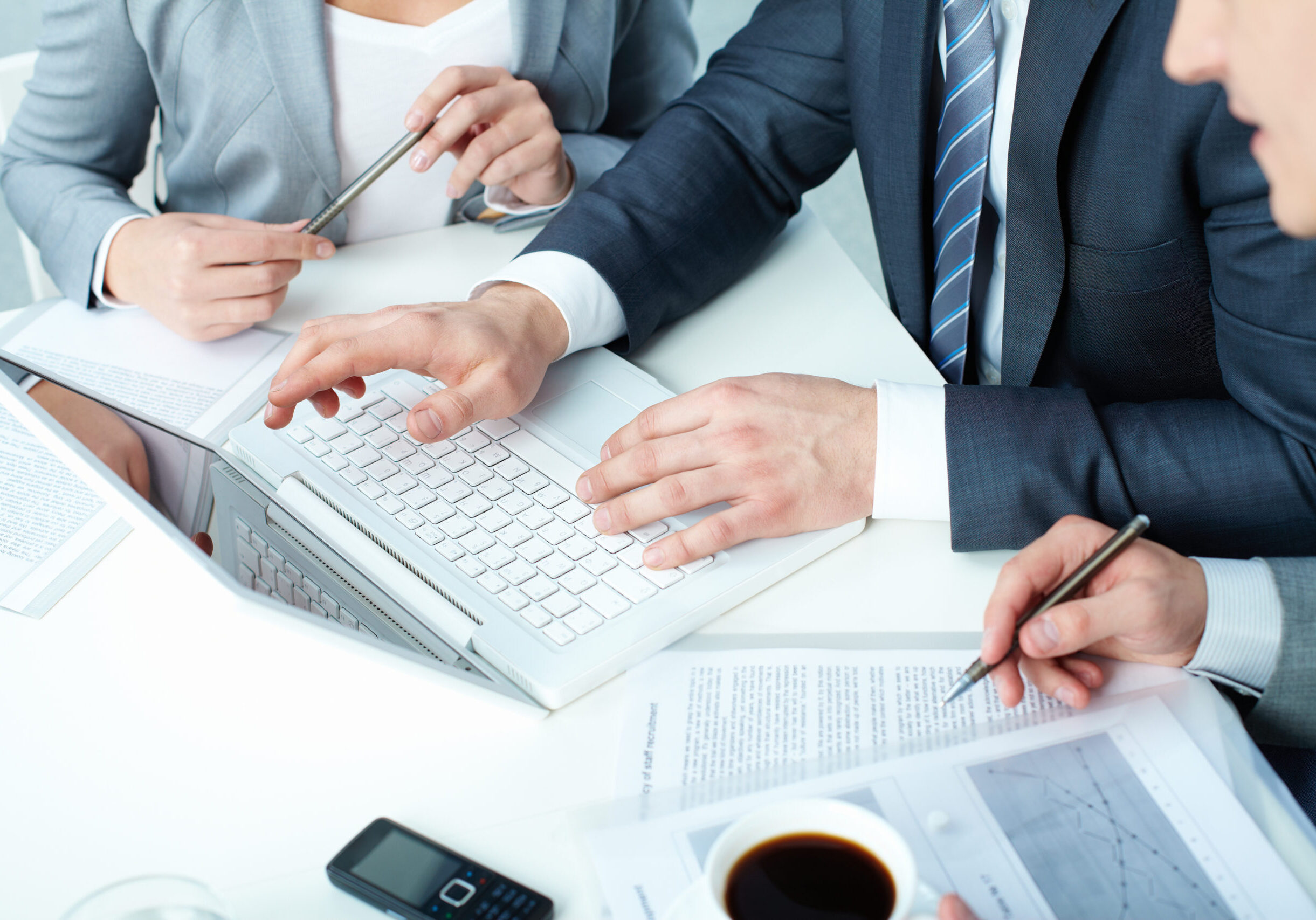 Eine-Gruppe-von-Geschaftsleuten-die-bei-einer-Besprechung-an-ihren-Laptops-arbeiten